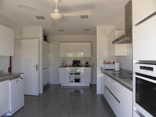 a white kitchen with white appliances and a ceiling at Villa Teresa in Agua Amarga