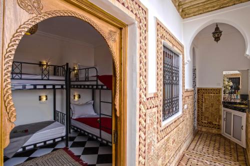 un arco che conduce a una camera con 2 letti a castello di Hostel Amour d'auberge a Marrakech