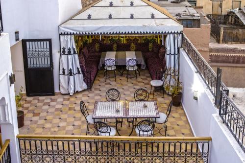 an outdoor patio with tables and chairs on a balcony at Hostel Amour d'auberge in Marrakech