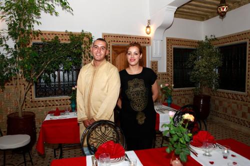 a man and a woman standing in a room with tables at Hostel Amour d'auberge in Marrakech