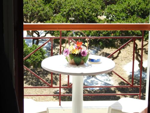 a table with a vase of flowers on a balcony at ChiosRoomsMaria in Armólia
