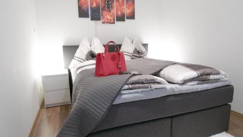 ein Bett mit einer roten Tasche darüber. in der Unterkunft Laguna Apartment in Wien