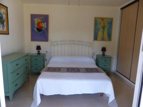 sypialnia z łóżkiem, 2 komodami i 2 obrazami w obiekcie Cortijillo Violeta w mieście Agua Amarga