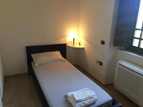 een kleine slaapkamer met een bed met een lamp erop bij Le Case del Parco in Peschici
