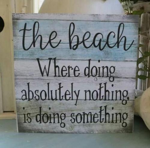 a sign that reads the beach where doing absolutely nothing is doing something at Sea breeze holiday apartment in Weymouth