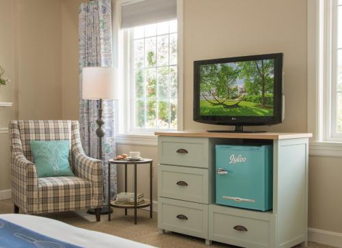 a living room with a tv and a dresser at The Essex Resort in Burlington