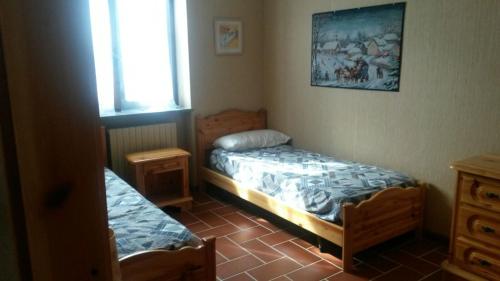 1 dormitorio con 2 camas individuales y ventana en Genevris, en Pragelato