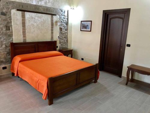 a bedroom with a bed with an orange comforter at Eleven Bed & Breakfast in Reggio di Calabria