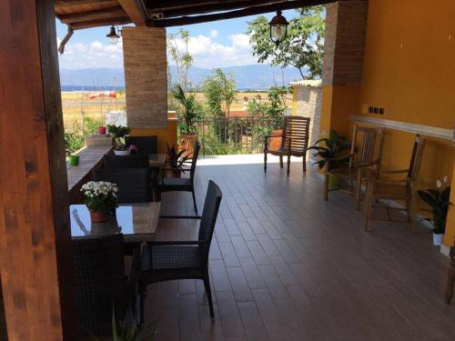 un patio con tavoli, sedie e vista di Eleven Bed & Breakfast a Reggio di Calabria