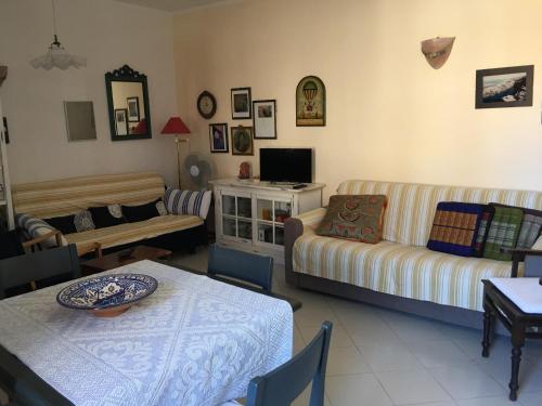 un soggiorno con divano e tavolo di Appartamento Rosas a Porto San Paolo