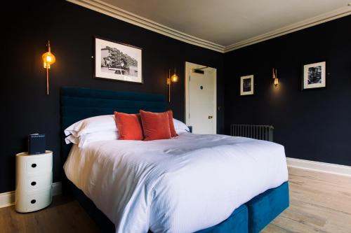 a bedroom with a large bed with red pillows at The Porterhouse grill & rooms in Oxford