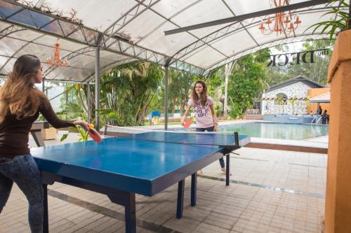 two women playing ping pong at a ping pong table at Residency Lake Resort & Spa in Mulshi