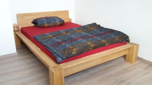 1 cama con marco de madera en una habitación en Schwalbennest, en Fürth