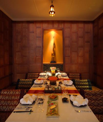 a dining room with a table with plates and wine glasses at Sarova Stanley in Nairobi