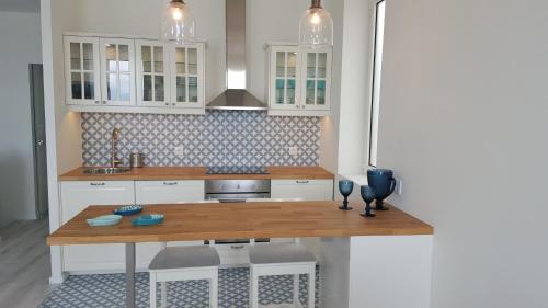 uma cozinha com armários brancos e uma mesa de madeira em The Shore @ BaíaBeach - Waterfront em Espinho