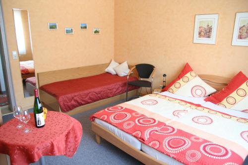 a hotel room with two beds and a table with a bottle of champagne at Ferienweingut Hensler in Briedel