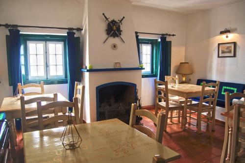 a living room with a fireplace and a table and chairs at Casa Do Relogio in Óbidos