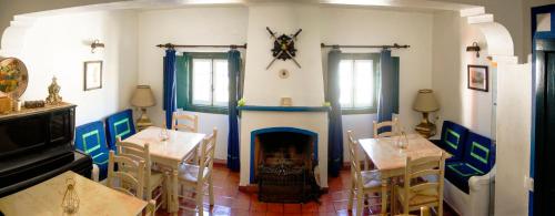 a dining room with two tables and a fireplace at Casa Do Relogio in Óbidos