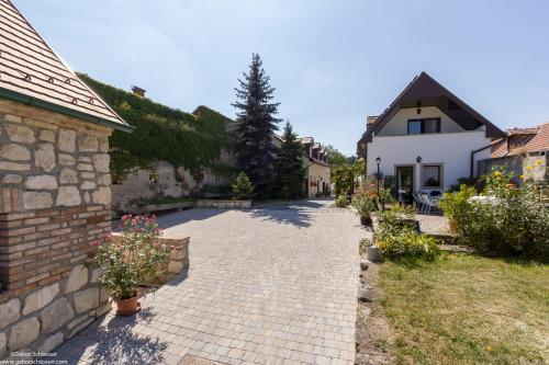 un chemin en briques menant à une maison fleurie dans l'établissement Várfal Vendégház, à Fertőrákos