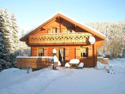 a log cabin with a balcony in the snow at Chalet Mauselaine in Xonrupt-Longemer