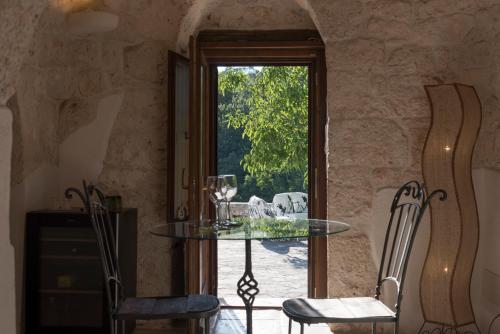 a dining room with a glass table and chairs at Dimora Casanoja in Noci
