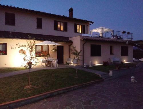 a large white house with a patio at night at Il Marrondindo Bed & Breakfast in Galliano