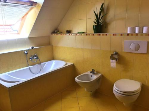 バダチョニトマイにあるPetra Apartmanházのバスルーム(バスタブ、トイレ、シンク付)