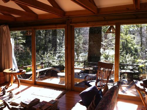 a screened in porch with a view of the woods at Linda Cabaña en Reserva HuiloHuilo in Puerto Fuy