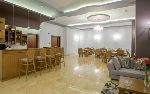 - un salon avec un canapé, une table et des chaises dans l'établissement Hotel Anna, à Ioannina