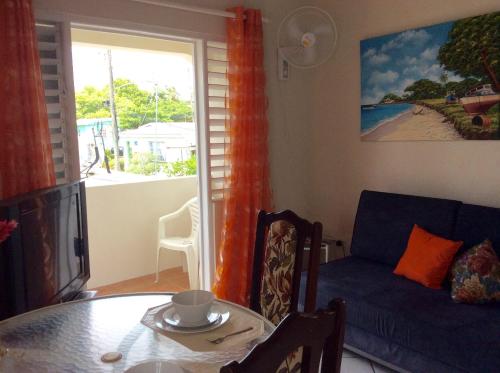 a living room with a table and a couch at Coconut cottage in Bridgetown