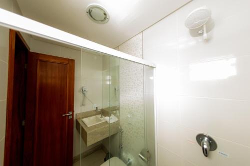 a bathroom with a shower and a sink and a mirror at Sollar hotel in Aracruz