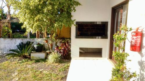 a house with a brick fireplace in a yard at Classe aluguéis apts in Imbé
