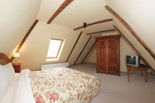 a bedroom with a bed and a tv at Pensiune Citadela Sighisoara in Sighişoara