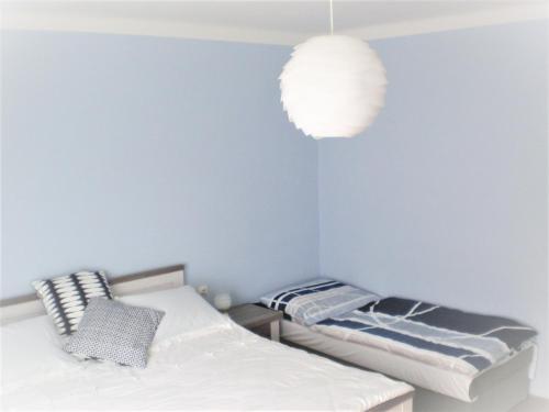 a bedroom with two beds and a light fixture at apartman pro 4 osoby in Česká Skalice