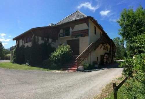 an old building with a porch and stairs on a road at Le Vieux Tilleul in Seyne