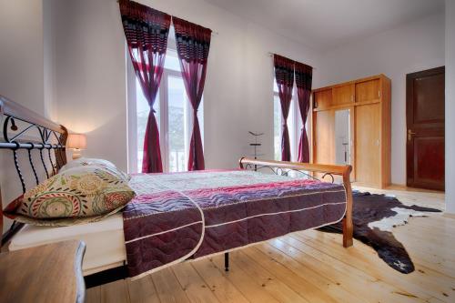 a bedroom with a bed with red curtains at Apartments Nikola Vidović in Komiža