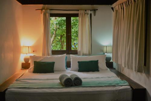 Un dormitorio con una cama con dos pares de zapatos. en Indigo Yoga Surf Resort, en Mal País