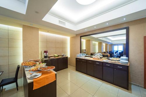 a large kitchen with many plates of food on a table at Hotel Tiempo in Naples