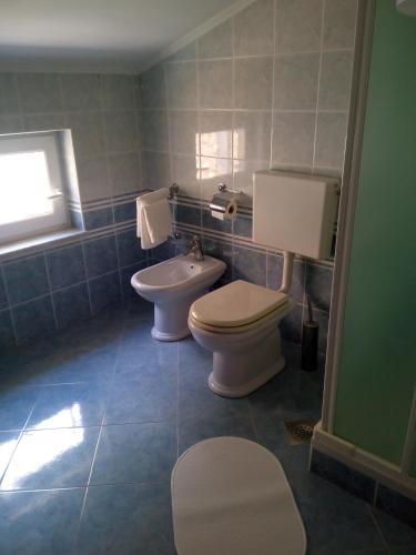 a bathroom with two toilets and a window at Seaside Apartment Barić Draga in Barić Draga