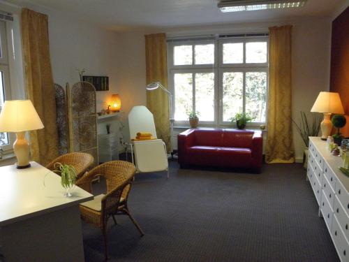 a living room with a red couch and a window at Parkhotel Helene in Bad Elster