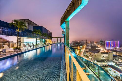 a swimming pool on the roof of a building at night at Cosmos Pacifico Hotel in Buenaventura