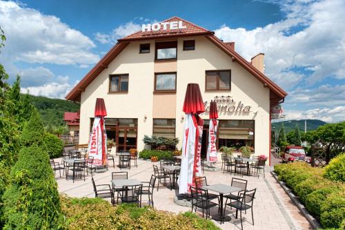 a hotel with tables and chairs in front of a building at Hotel Magnolia in Kielce