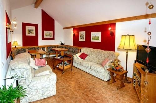 a living room with two couches and a television at Weinstube Pension Moselblümchen in Zeltingen-Rachtig