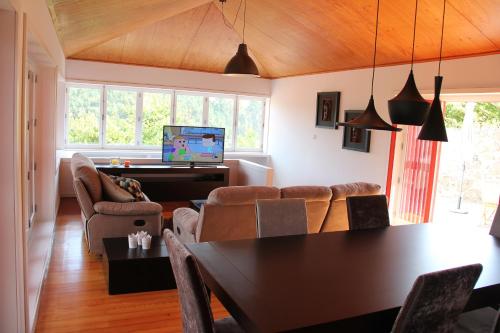 a living room with a table and chairs and a piano at Casa da Bichaca in Castelo de Paiva