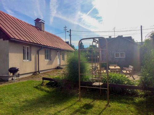 a yard with a house and a table and a fence at UusAllika Puhkemaja in Haapsalu