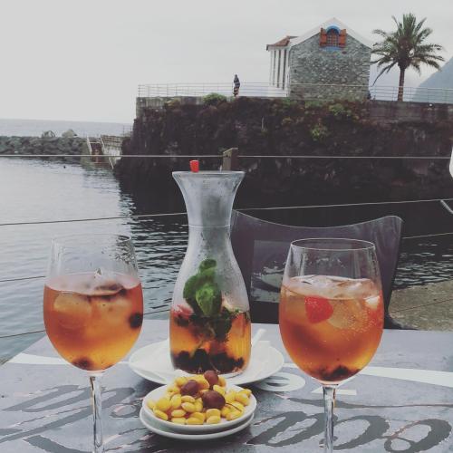 two glasses of drinks and a vase on a table at Ape Esquerdo in São Vicente