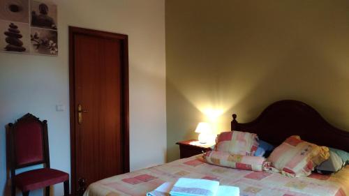 a bedroom with a bed and a red chair at Ape Esquerdo in São Vicente