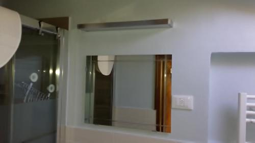 a mirror on a wall in a bathroom at Casa Maria Teresa in San Donato in Poggio