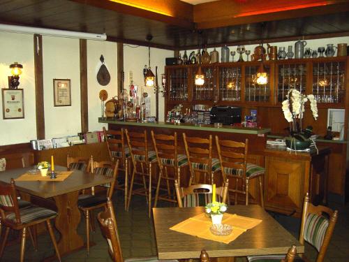 ツェルティンゲン・ラハティグにあるWeinstube Pension Moselblümchenの木製のテーブルと椅子のあるレストラン、バー