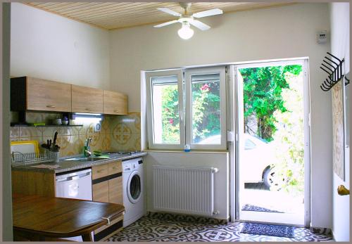 a kitchen with a washing machine and a window at White & Quiet Apartment House in Hévíz